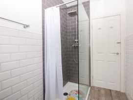 A bathroom with a shower and door at Seabreeze in Llandudno