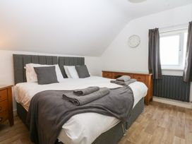 A bedroom with a bed and wooden furniture at Seabreeze in Llandudno
