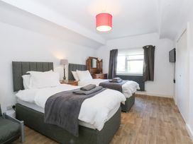 A bedroom with two beds and a dressing table at Seabreeze in Llandudno