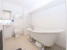 A bathroom with a bathtub, toilet, and sink at Seabreeze in Llandudno