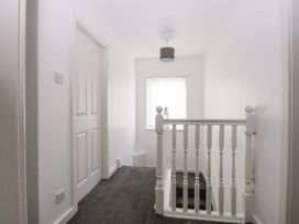 A hallway with a staircase and a window at Seabreeze in Llandudno