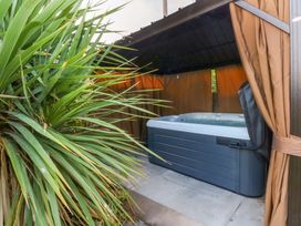 A hot tub in a sheltered area with curtains at Seabreeze in Llandudno