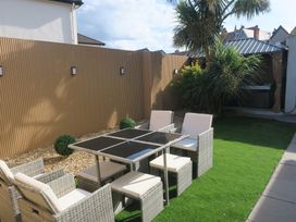 A garden with a dining table and chairs at Seabreeze in Llandudno