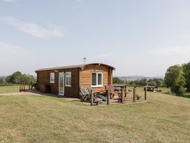 A cabin with a deck and surrounding landscape at Twilight in Raglan
