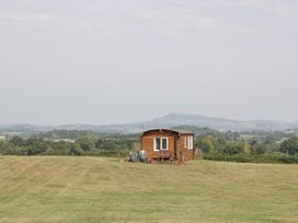 A cabin on a lawn with a tractor at Twilight, Raglan