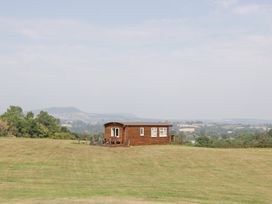 A cabin with a deck situated on grassland at Twilight in Raglan