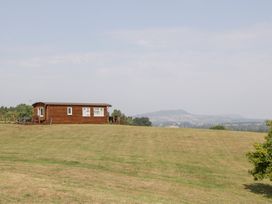 A log cabin on a grassy field at Twilight in Raglan