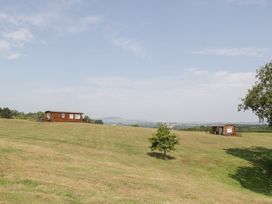 Two houses on a lawn with a tree and mountains in the background at Twilight in Raglan