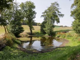 A pond surrounded by trees in Twilight, Raglan