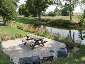 An outdoor area with a picnic table and grill at Twilight in Raglan