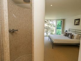 A bedroom with a bed and pillows next to a tiled shower at 6 Red Sails in Sandbanks