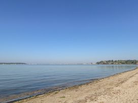 A sandy beach with calm water and clear sky at 6 Red Sails in Sandbanks