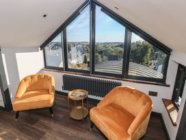 A living room with two armchairs and a side table at 10 Brython Place in Tenby