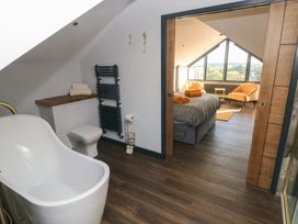 A bathroom with a bathtub and toilet at 10 Brython Place in Tenby