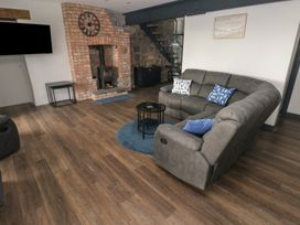 A living room with a sofa and fireplace at 10 Brython Place in Tackley