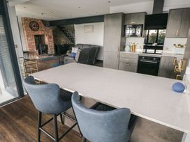 A kitchen with bar stools and cabinets at 10 Brython Place Tackley