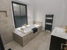 A bathroom with a bathtub and sink at 10 Brython Place in Tackley