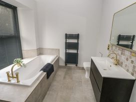 A bathroom with a bathtub, toilet, and sink at 10 Brython Place Tackley
