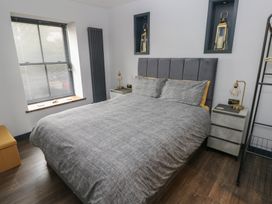 A bedroom featuring a bed and bedside table at 10 Brython Place Tackley