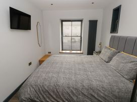 A bedroom with a bed, television and window at 10 Brython Place, Tackley