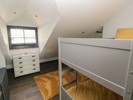 A bedroom with a bunk bed and dresser at 10 Brython Place in Tackley