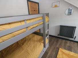 A bedroom with a bunk bed and radiator at 10 Brython Place in Tackley