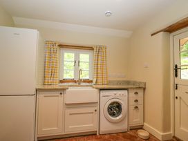 A kitchen with a sink and washing machine at Keepers Cottage in Devizes