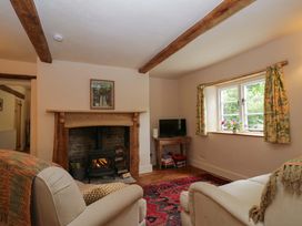 A living room with a fireplace and television at Keepers Cottage in Devizes