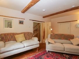 A living room with sofas and a rug at Keepers Cottage in Devizes