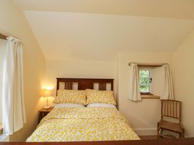 A bedroom with a bed and lamp at Keepers Cottage in Devizes