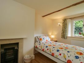 A bedroom with a bed and bedside lamp at Keepers Cottage in Devizes