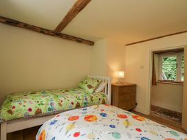 A bedroom with two beds and a lamp at Keepers Cottage in Devizes
