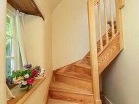 A staircase with a window and flowers at Keepers Cottage in Devizes