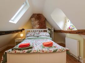 A bedroom with a bed and a nightstand at Keepers Cottage in Devizes