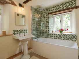 A bathroom with a bath tub and sink at Keepers Cottage in Devizes