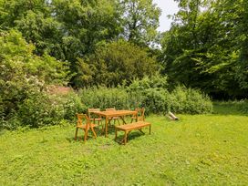A wooden table and chairs in a garden at Keepers Cottage, Devizes