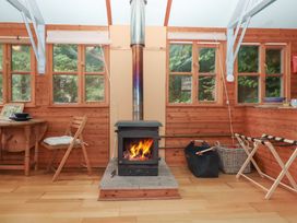 A living room with a wood stove and table at The Boat House in Ashprington