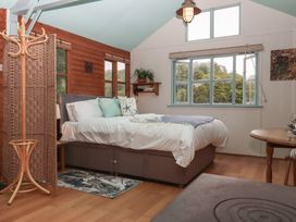 A bedroom with a bed and windows at The Boat House in Ashprington