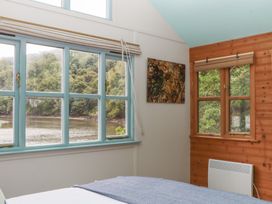 A bedroom with windows and a view at The Boat House in Ashprington