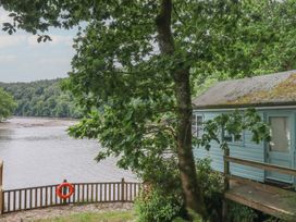 A view of a house and a river surrounded by trees at The Boat House in Ashprington