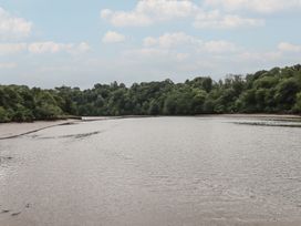 A river surrounded by trees and a cloudy sky at The Boat House in Ashprington