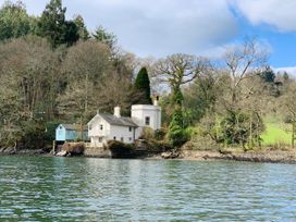 A house near water with trees surrounding it at The Boat House in Ashprington