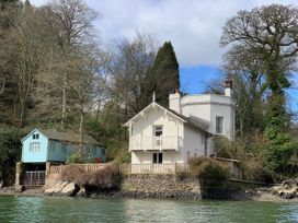 A house with a balcony next to a boathouse at The Boat House in Ashprington