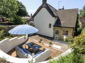 A garden with outdoor furniture and an umbrella at Happiness Cottage in Piddlehinton
