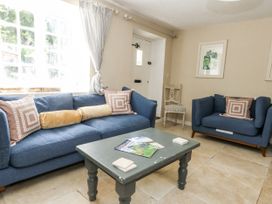 A living room with blue sofas and a coffee table at Happiness Cottage in Piddlehinton