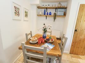 A dining room with a table set for breakfast at Happiness Cottage in Piddlehinton