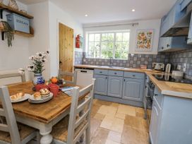 A kitchen with a table and chairs at Happiness Cottage in Piddlehinton
