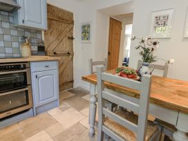 A kitchen with a wooden table and chairs at Happiness Cottage in Piddlehinton