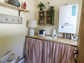 A utility room with boiler, coffee maker, and lamp at Happiness Cottage in Piddlehinton