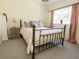 A bedroom with a bed and dresser at Happiness Cottage Piddlehinton